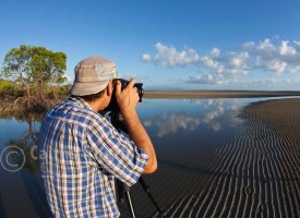 Image of photographer taking a photo on beach, Port Douglas, North Queensland, Australia